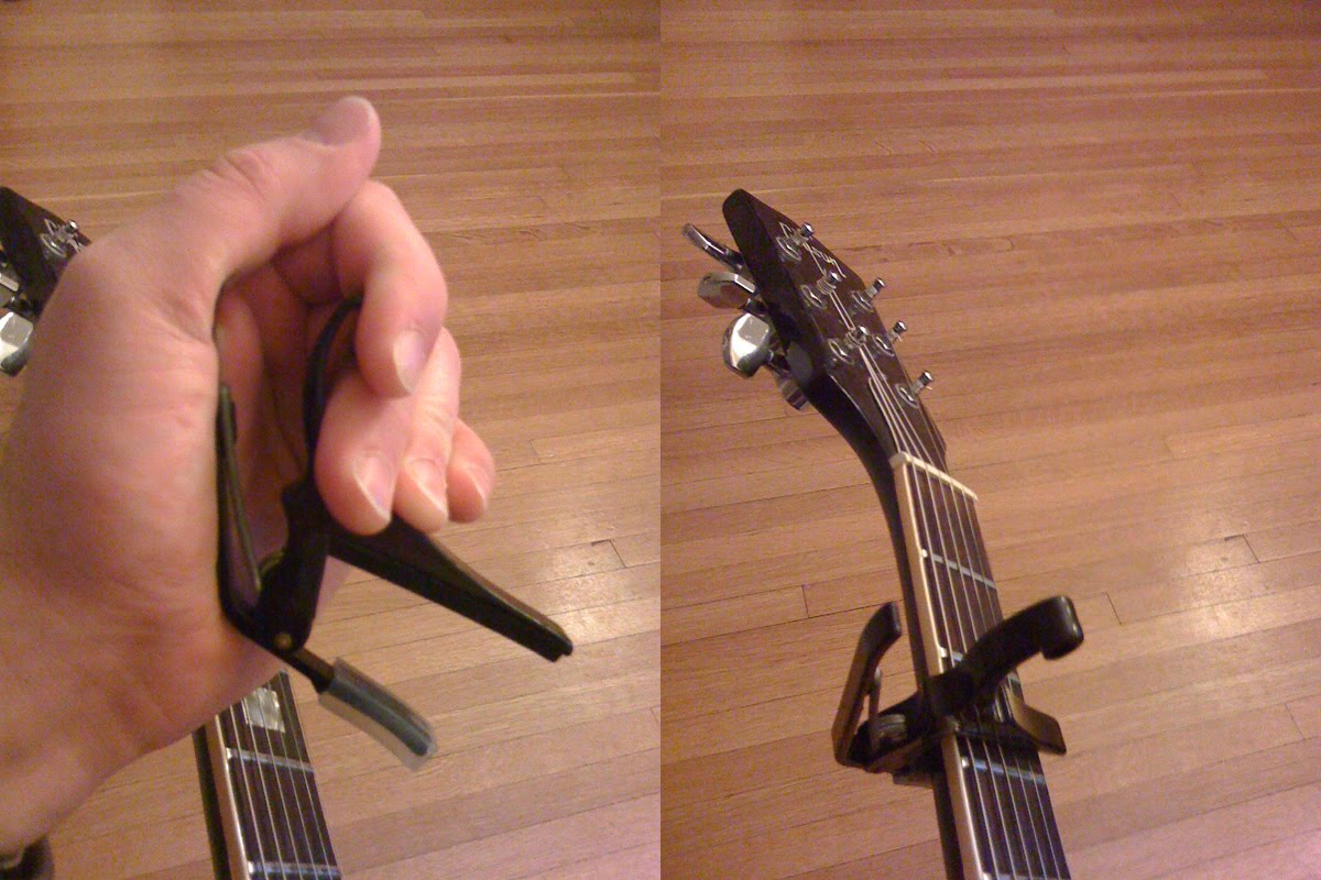 A guitar capo in use