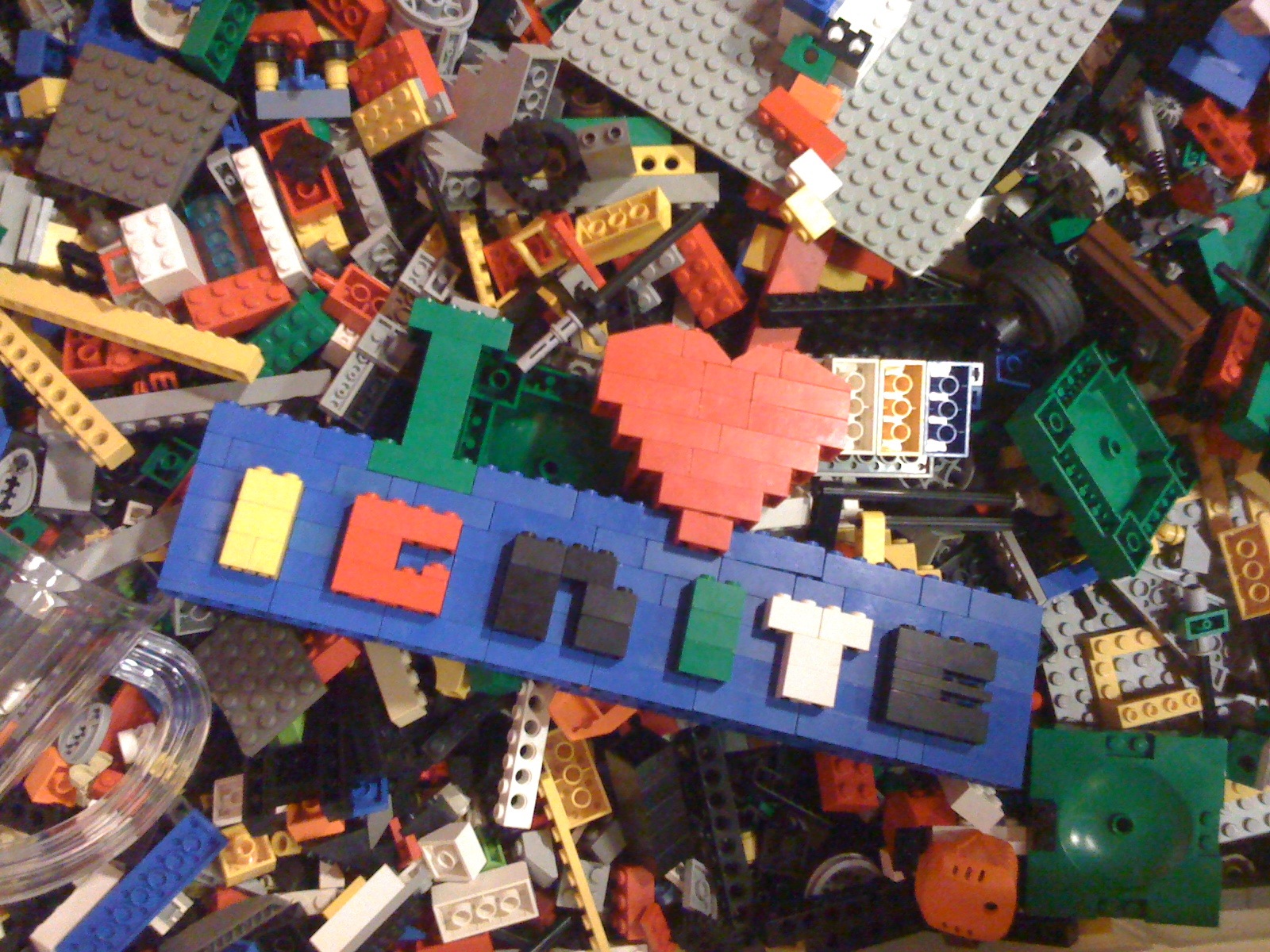 A bin full of varied and colourful Lego pieces