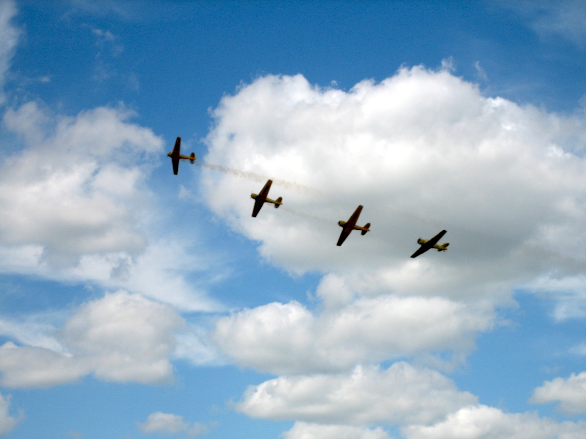 Four Harvard aircraft flyng in a cloudy sky