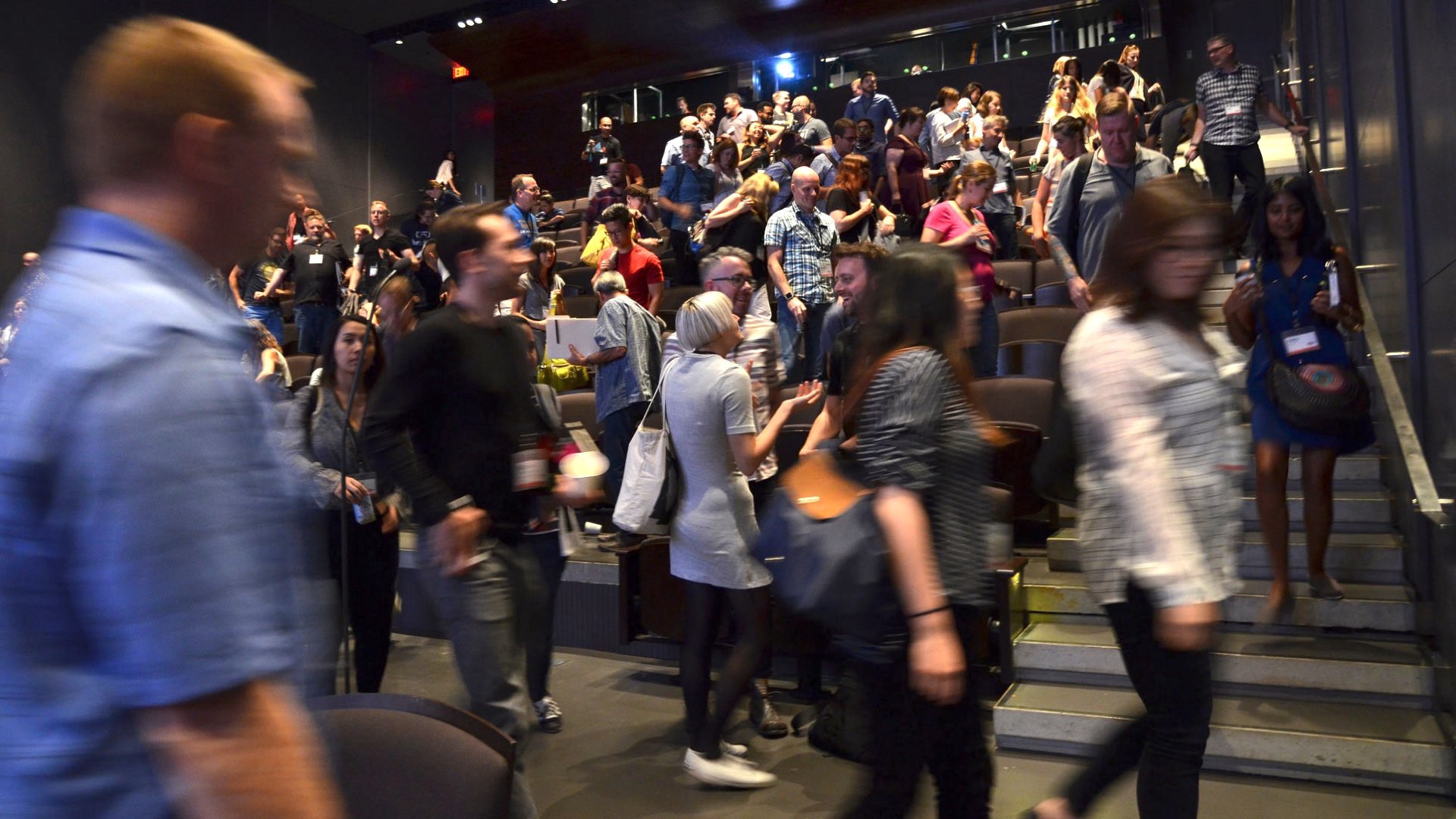 A crowd of people leaving an auditorium